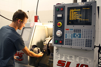 Machining/Engineering Tech student operating CNC machine.