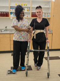 Two female Health Services students with a walker
