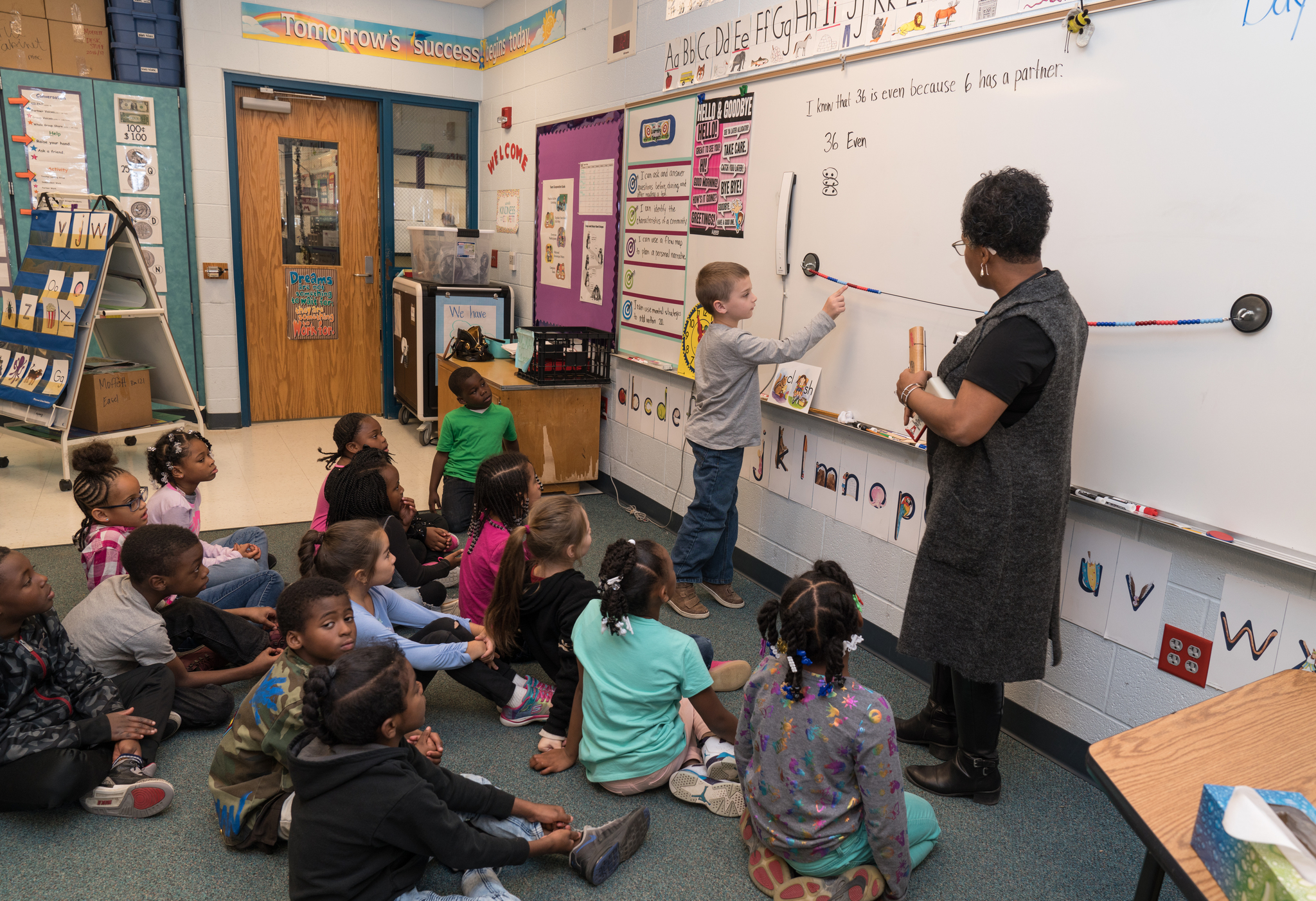 Elementary students working on math problems with teacher
